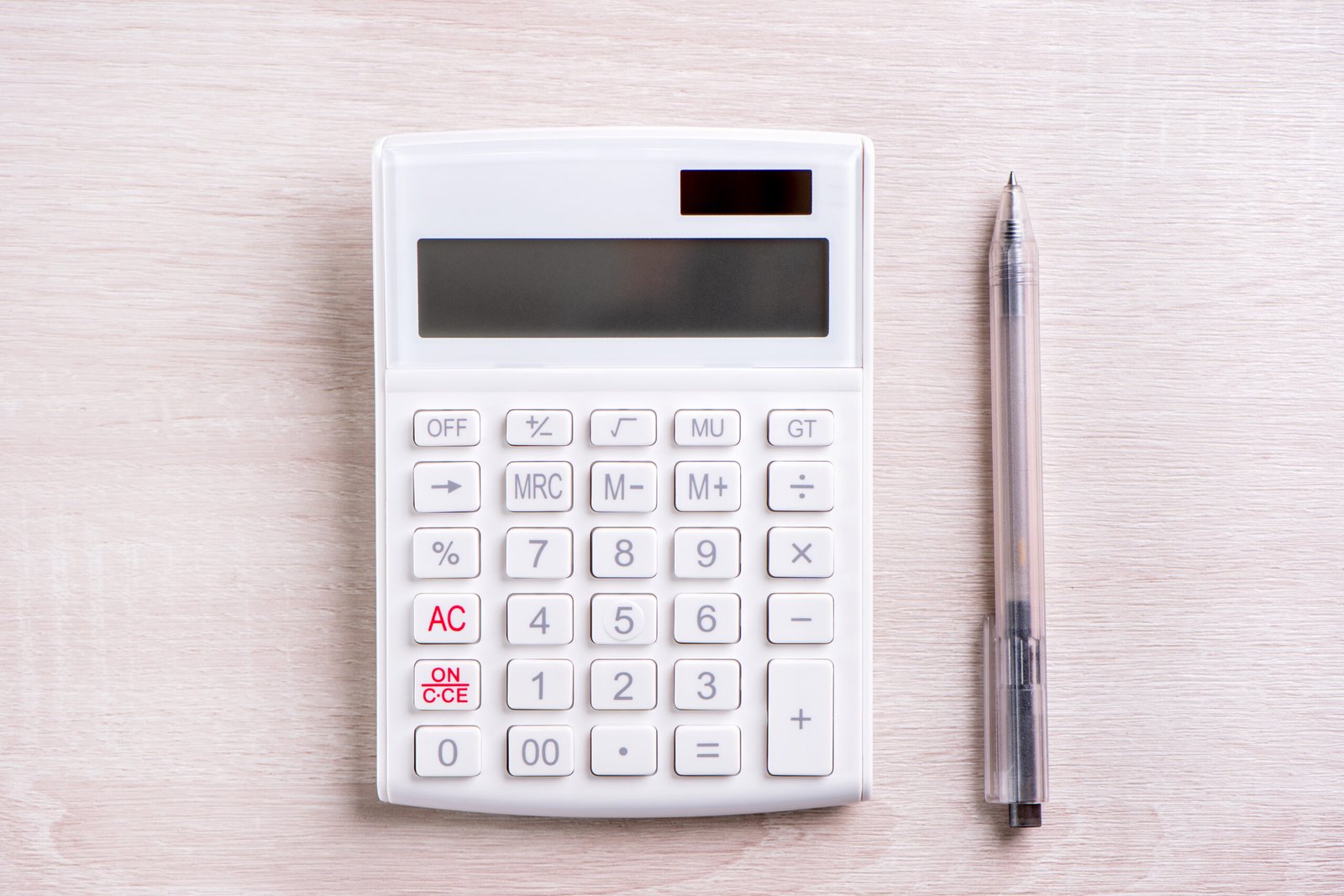 Calculator and pen on a wooden table